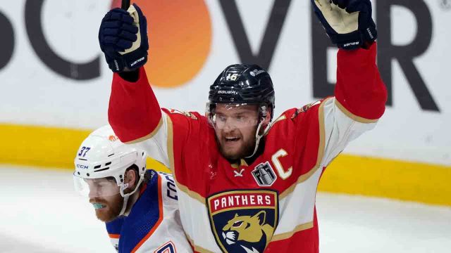 Aleksander Barkov of the Panthers passes Stanley Cup to teammate Sergei Bobrovsky